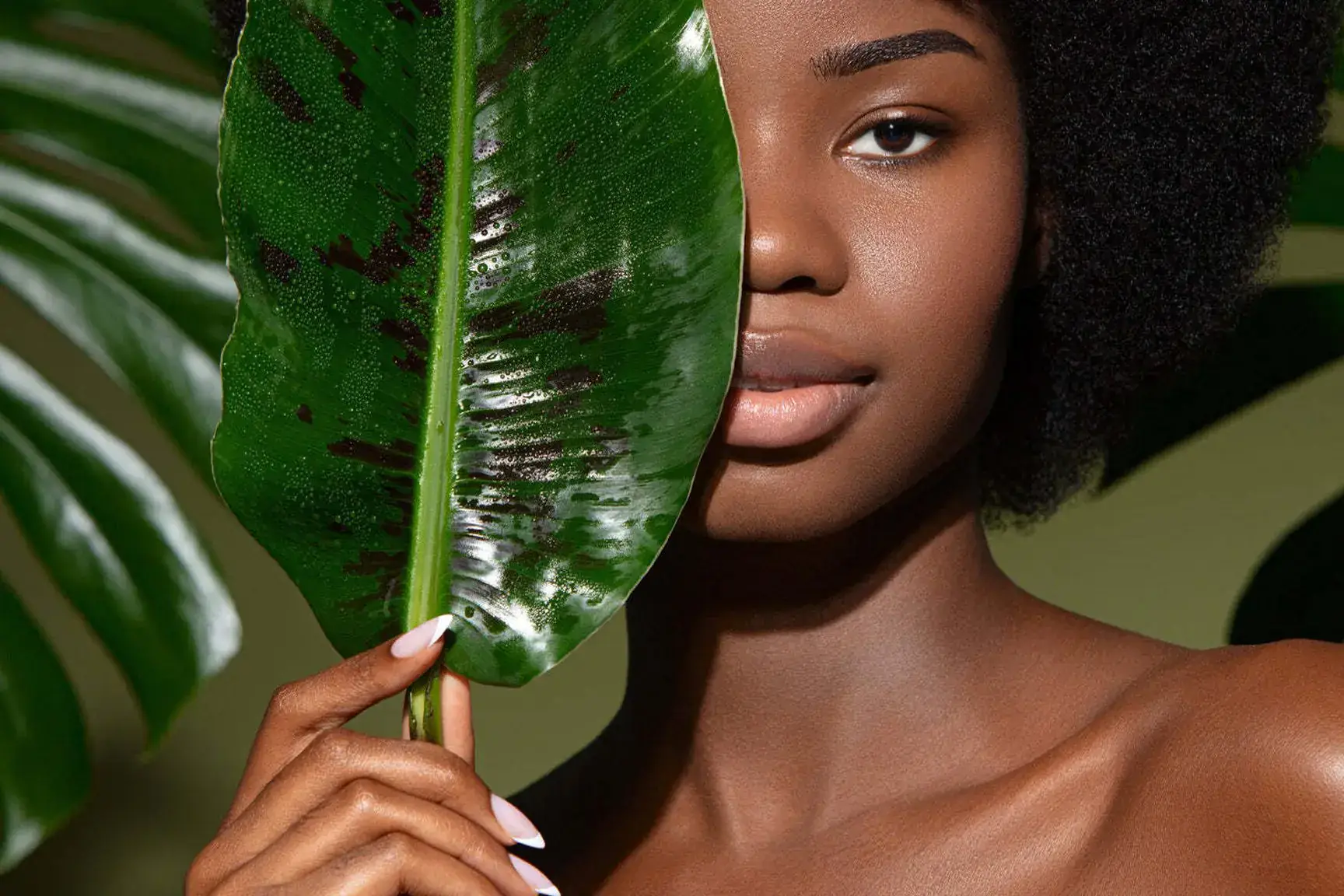 Woman framed by a tropical green leaf